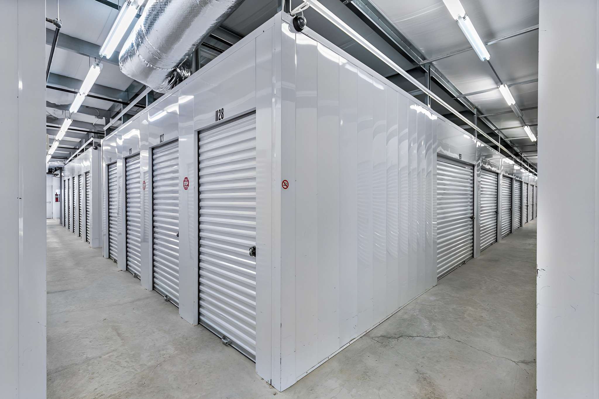 Temperature controlled storage unit interior with white doors at Harbor Point Storage, Vero Beach, FL, featuring elevator access and monitored by security cameras for optimal safety and convenience.